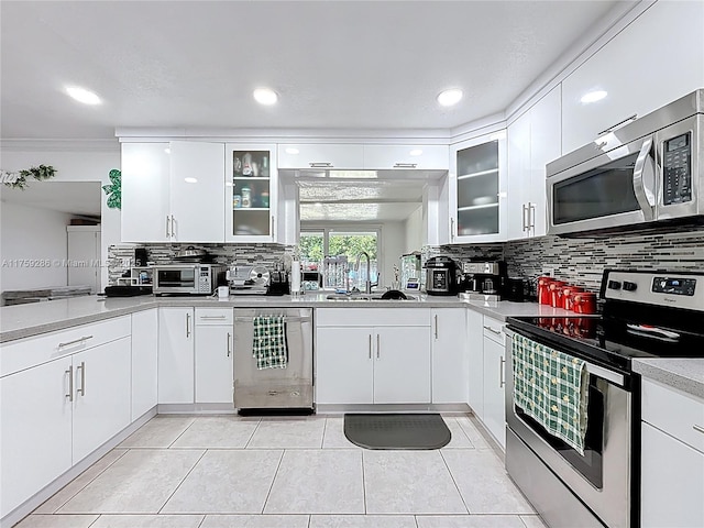 kitchen featuring a sink, decorative backsplash, light countertops, white cabinets, and appliances with stainless steel finishes