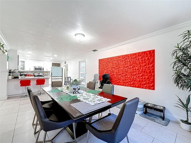 dining space featuring visible vents, a textured ceiling, crown molding, light tile patterned floors, and baseboards