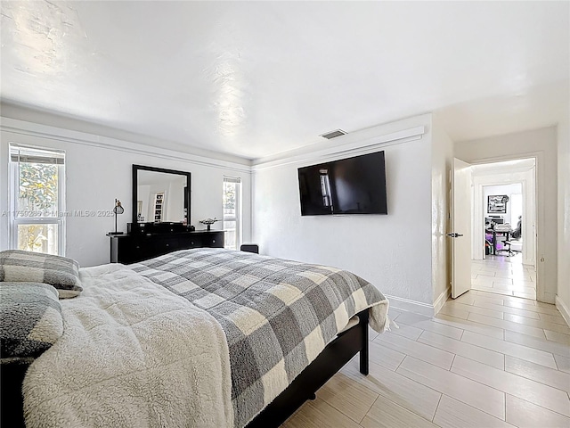 bedroom with visible vents, multiple windows, and baseboards