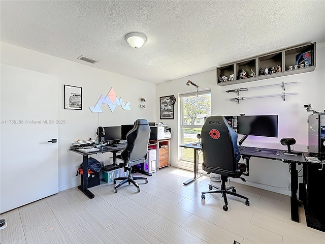 home office with visible vents and a textured ceiling