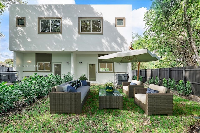 back of property featuring an outdoor living space, stucco siding, and a fenced backyard