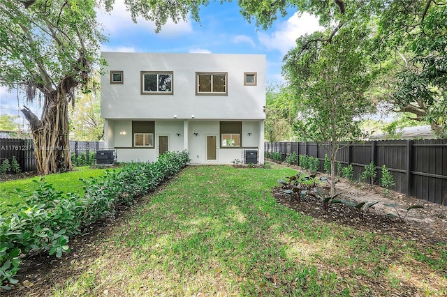 back of property featuring a yard, central air condition unit, stucco siding, and a fenced backyard