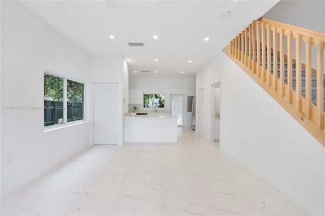 unfurnished living room featuring recessed lighting, visible vents, baseboards, and marble finish floor