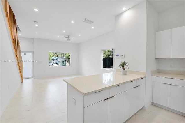 kitchen featuring visible vents, recessed lighting, a peninsula, white cabinets, and a ceiling fan