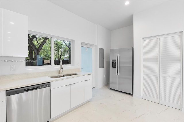 kitchen with a sink, light countertops, marble finish floor, and stainless steel appliances