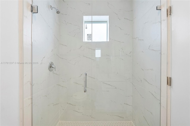 bathroom featuring a marble finish shower