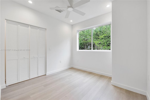 unfurnished bedroom with a closet, recessed lighting, baseboards, and light wood-style floors