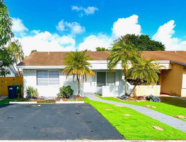 ranch-style house with stucco siding and a front lawn