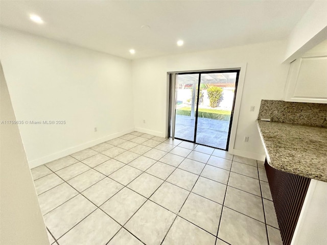 spare room featuring recessed lighting, baseboards, and light tile patterned floors