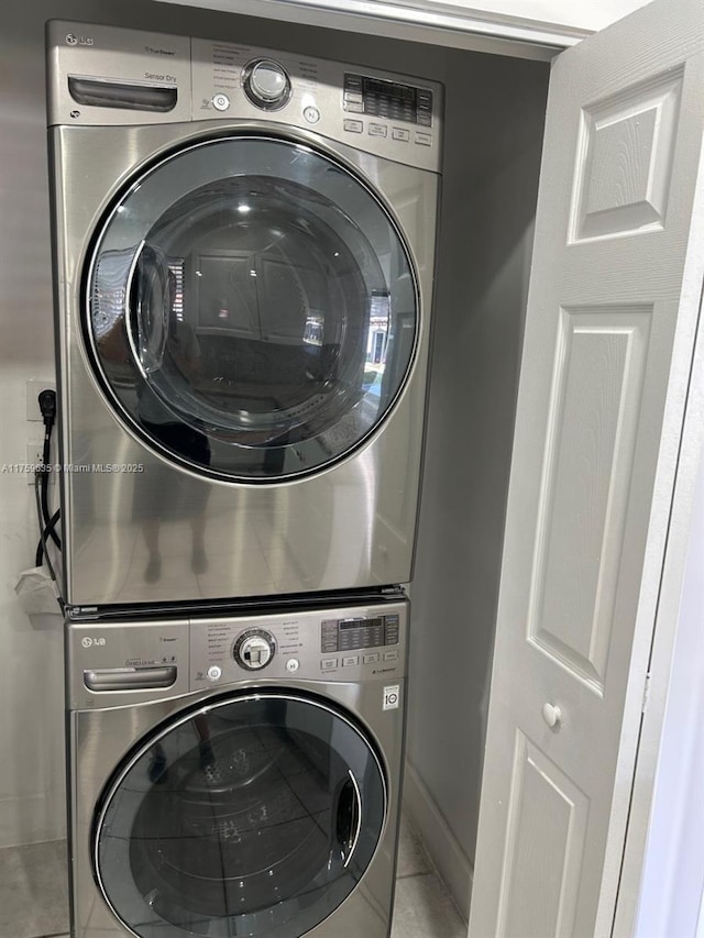 laundry room featuring baseboards, stacked washer and dryer, and laundry area