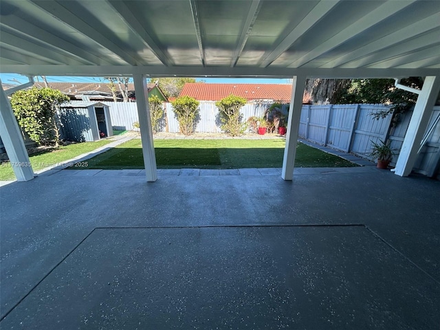 view of patio / terrace featuring a storage shed, a fenced backyard, and an outdoor structure