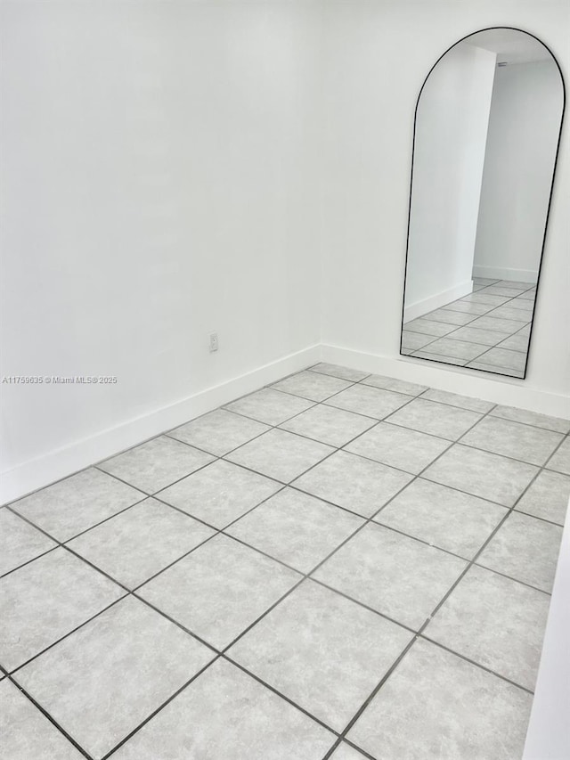 unfurnished room with arched walkways and baseboards