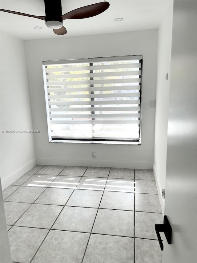 tiled spare room with plenty of natural light, baseboards, and ceiling fan