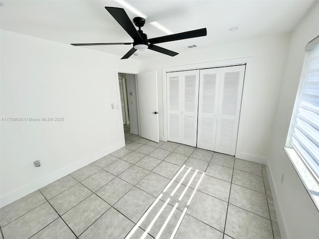 unfurnished bedroom featuring a closet, visible vents, baseboards, and light tile patterned floors