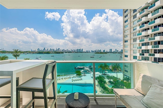 balcony featuring a city view and a water view