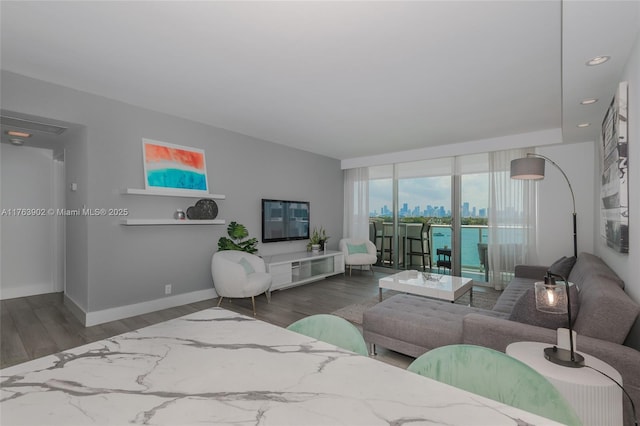 living area featuring a view of city, recessed lighting, wood finished floors, and baseboards