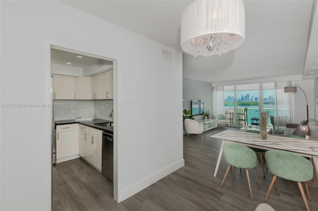 dining space with dark wood finished floors, visible vents, floor to ceiling windows, and baseboards