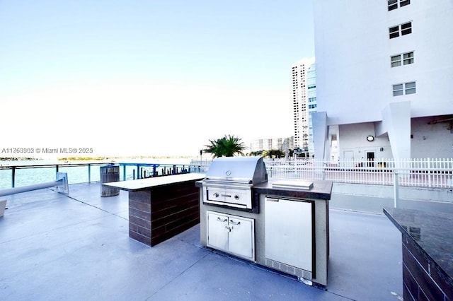 view of patio / terrace with area for grilling, an outdoor kitchen, and fence