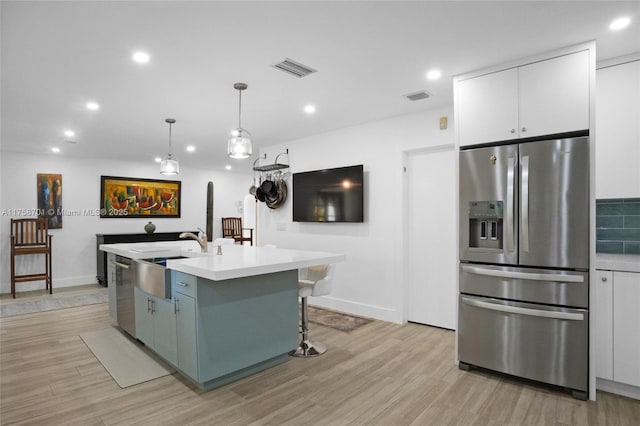 kitchen with visible vents, white cabinets, appliances with stainless steel finishes, and light wood-style floors