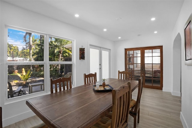 dining area with arched walkways, recessed lighting, french doors, and a healthy amount of sunlight