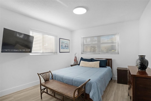 bedroom featuring baseboards and light wood finished floors