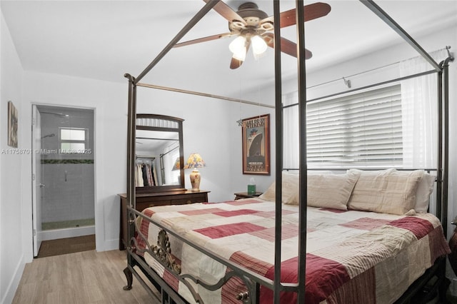 bedroom with connected bathroom, baseboards, wood finished floors, and a ceiling fan