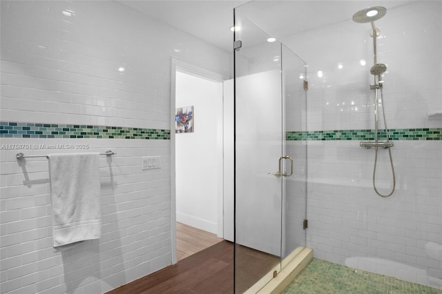 bathroom with wood finished floors and a stall shower