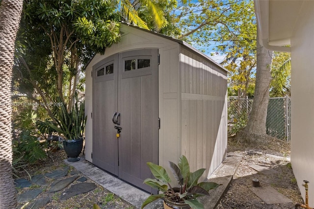 view of shed featuring fence