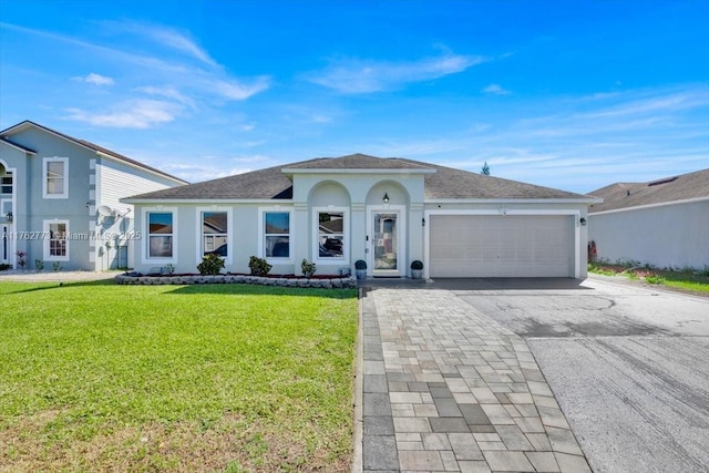 view of front of property with stucco siding, driveway, roof with shingles, a front yard, and a garage