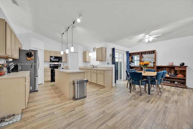 kitchen featuring black appliances, a kitchen island with sink, lofted ceiling, and a sink