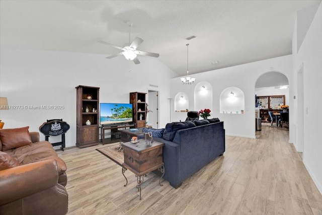 living room featuring arched walkways, visible vents, light wood-style flooring, and ceiling fan