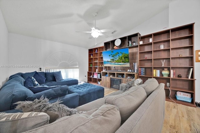 living area featuring light wood-style floors, ceiling fan, and vaulted ceiling