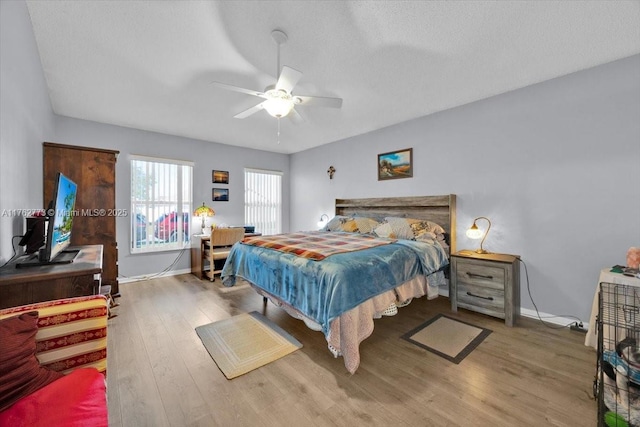 bedroom featuring wood finished floors, baseboards, and ceiling fan