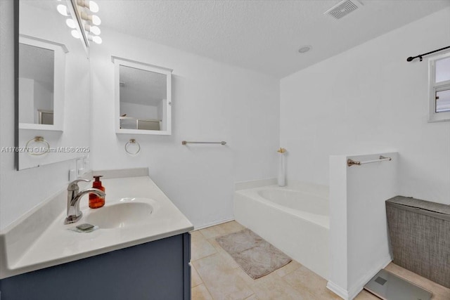 full bathroom with visible vents, vanity, a garden tub, tile patterned floors, and a textured ceiling