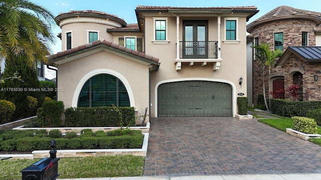 mediterranean / spanish-style home featuring a tiled roof, stucco siding, and an attached garage