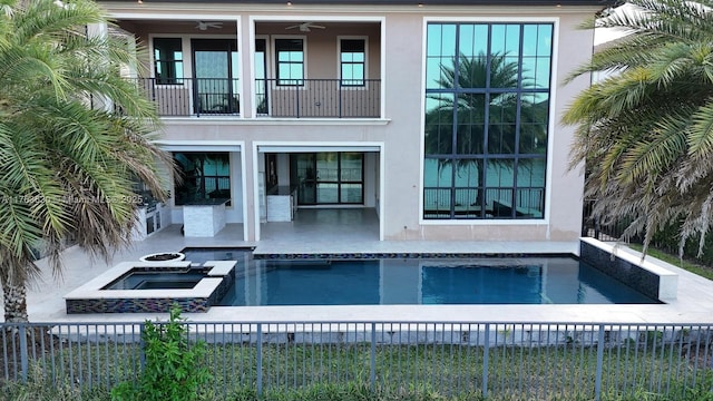 back of house with a balcony, fence, and ceiling fan