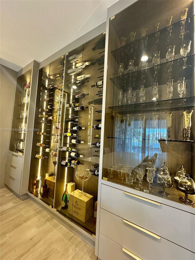 wine area featuring a textured ceiling and wood finished floors