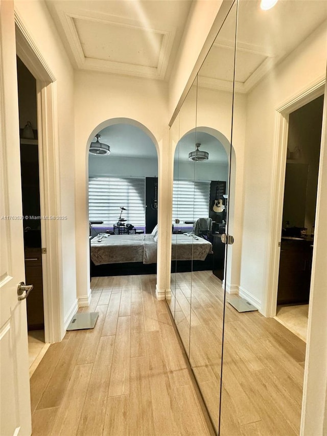 hallway with light wood-type flooring and baseboards