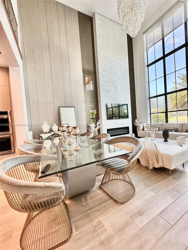 interior space featuring wood finished floors, a high ceiling, a notable chandelier, and a healthy amount of sunlight