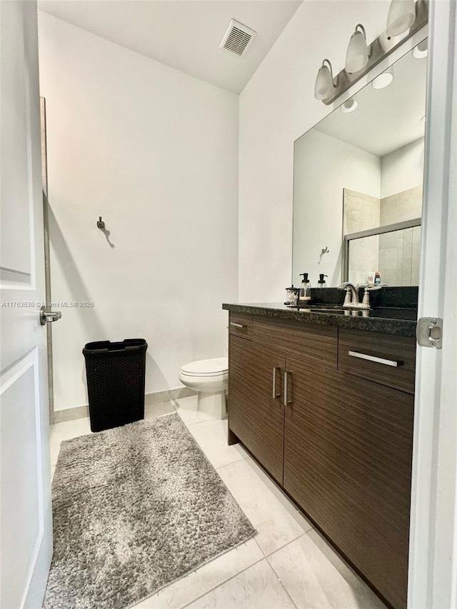 bathroom with visible vents, vanity, a shower stall, and toilet