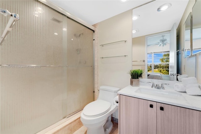 ensuite bathroom with vanity, ceiling fan, a shower stall, toilet, and connected bathroom