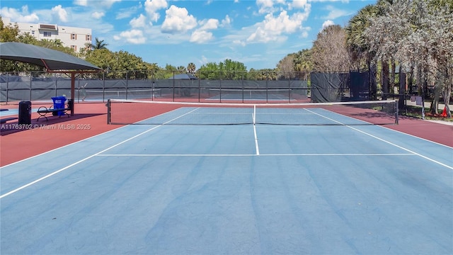 view of tennis court featuring community basketball court and fence