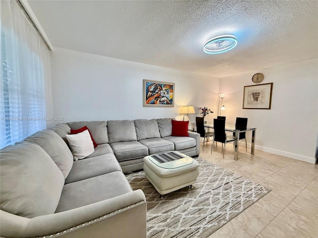 living room with a textured ceiling and baseboards