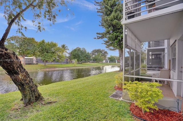 view of yard with a water view and a sunroom