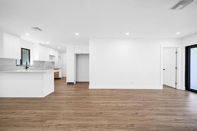 kitchen featuring wood finished floors, visible vents, recessed lighting, light countertops, and white cabinets