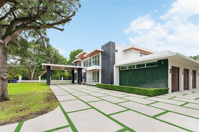 view of front of property featuring a garage, stucco siding, driveway, and a front yard