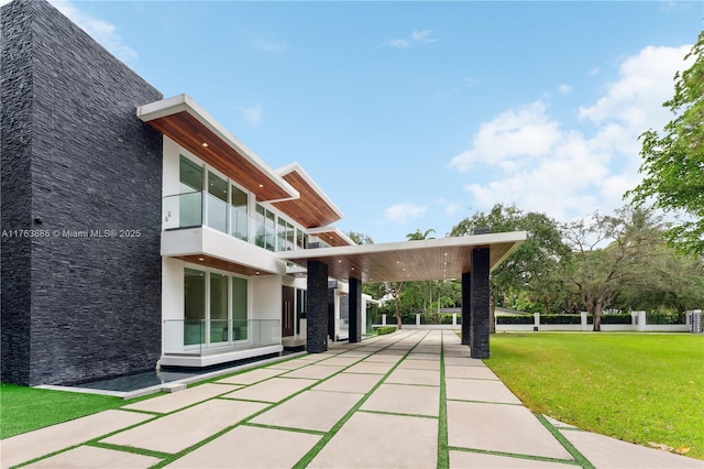 view of community featuring concrete driveway and a yard