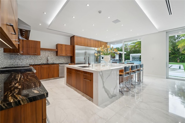 kitchen with brown cabinets, appliances with stainless steel finishes, marble finish floor, modern cabinets, and a sink