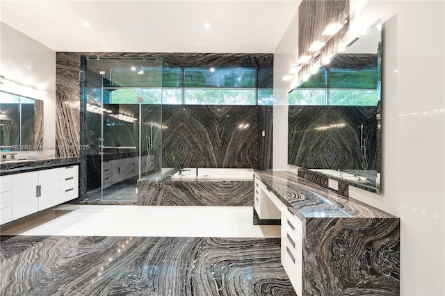 bathroom with vanity and a tub with marble appearance