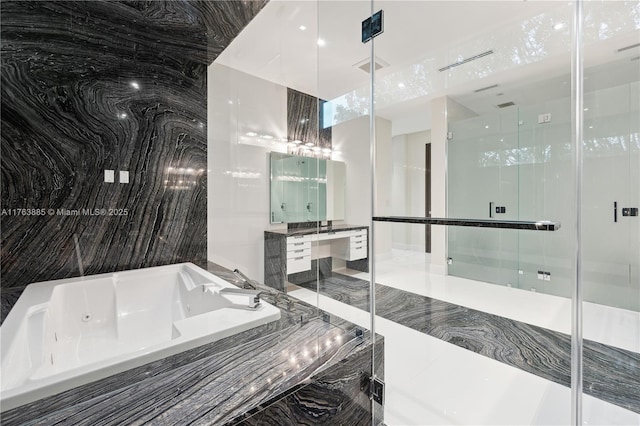 full bathroom featuring tile walls, a tub with jets, a shower stall, and vanity